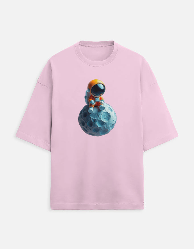 Pink t-shirt with cute cartoon astronaut sitting on a blue moon graphic