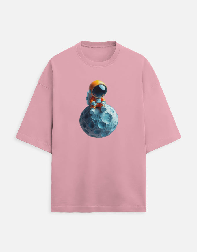 Pink t-shirt with cute astronaut sitting on blue moon graphic print, space-themed apparel
