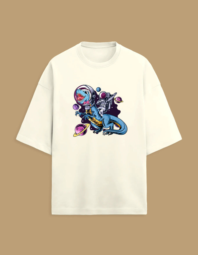 White T-shirt with astronaut riding a dinosaur in outer space graphic, beige background.