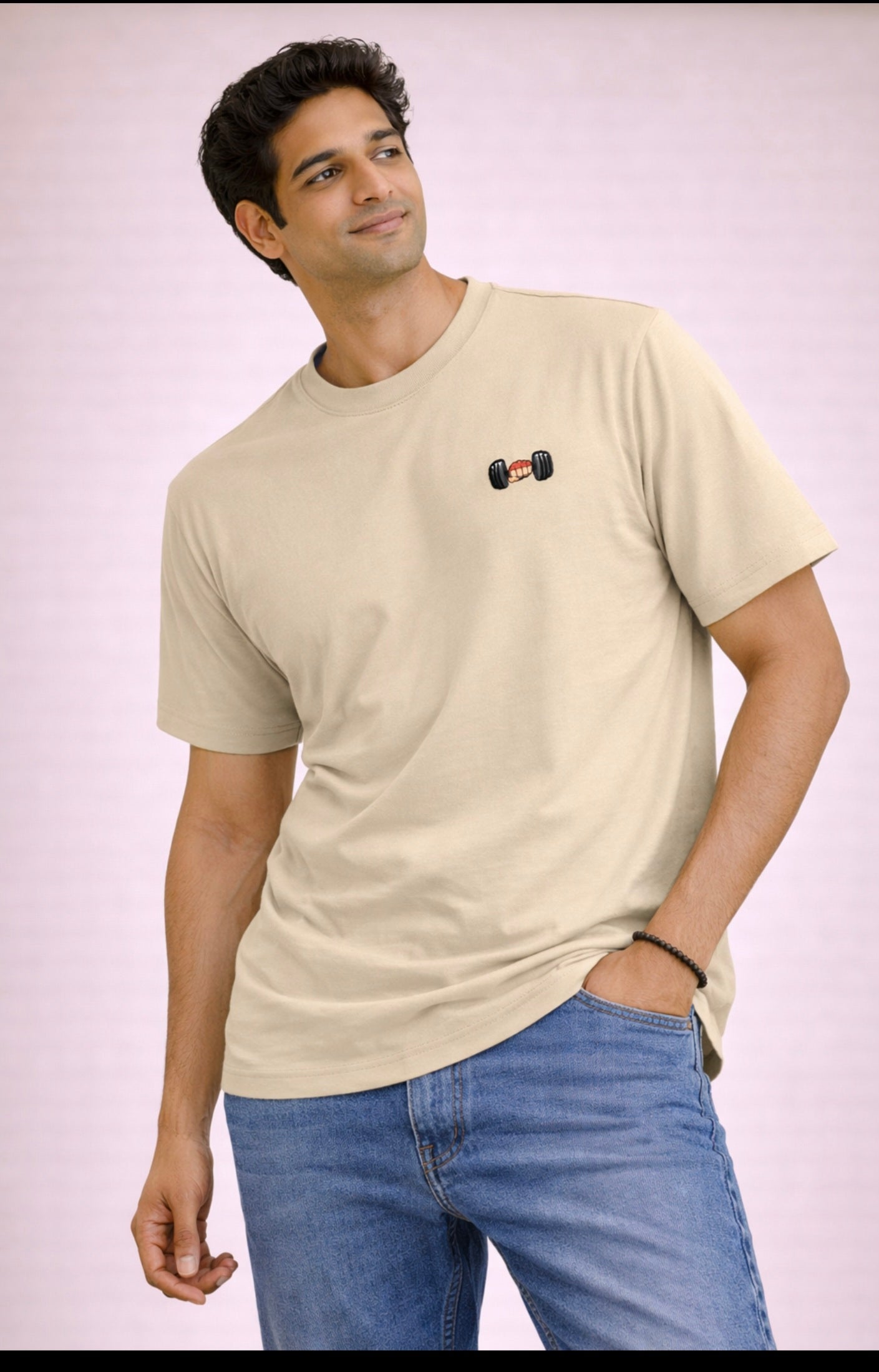 Man wearing a beige t-shirt with a small logo on a plain background