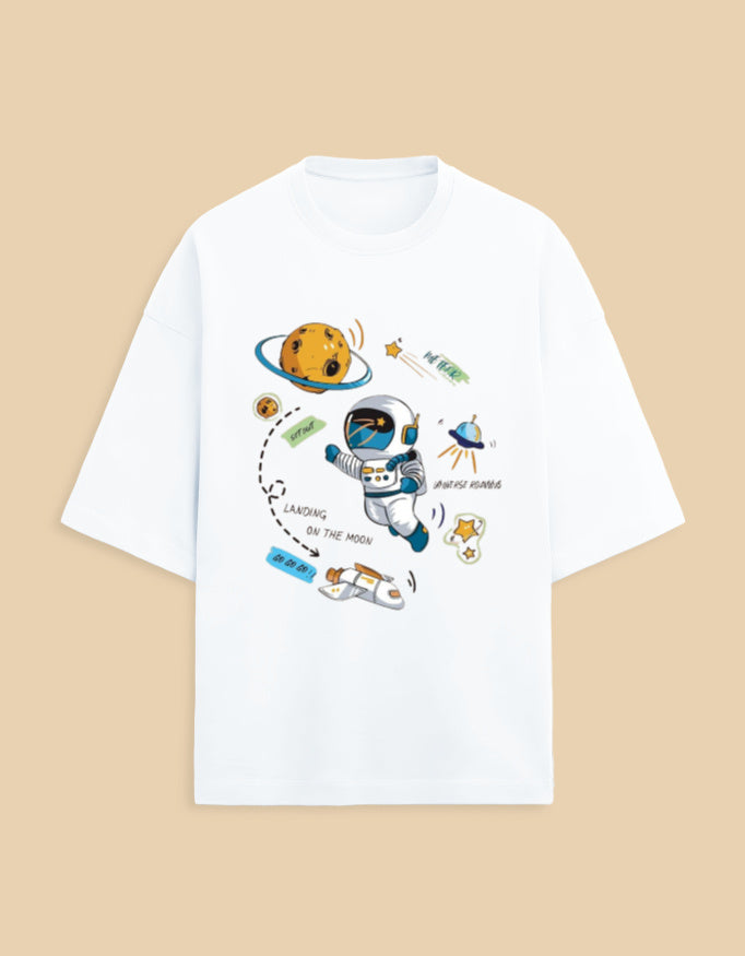 White t-shirt with cartoon astronaut, moon, stars, and spaceship space-themed graphic print
