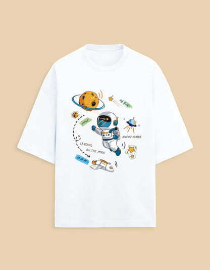White t-shirt with cartoon astronaut, moon, stars, and spaceship space-themed graphic print