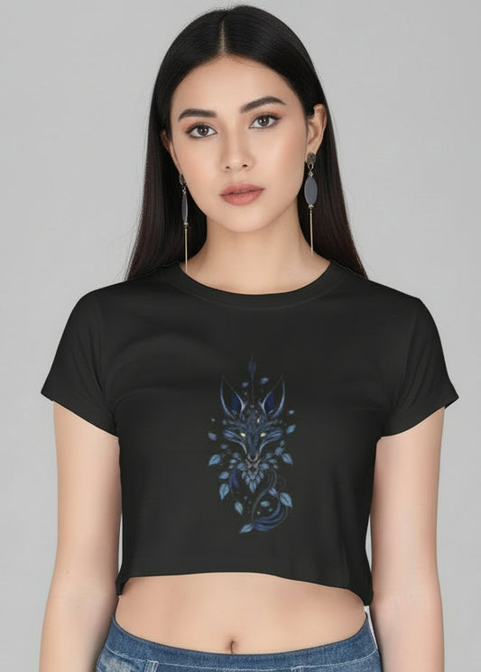 Woman wearing a black crop top with blue floral design and denim shorts on a brown background