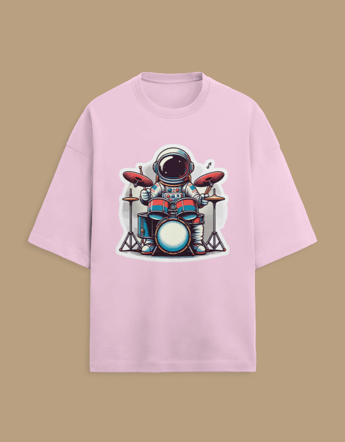 Pink t-shirt with cartoon astronaut playing drums graphic, isolated on beige background