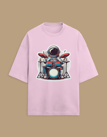 Pink t-shirt with cartoon astronaut playing drums graphic, isolated on beige background