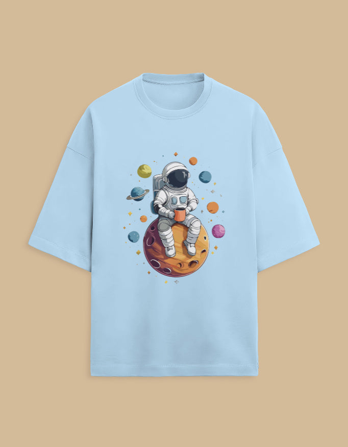 Light blue t-shirt with astronaut drinking coffee on planet and colorful space illustration