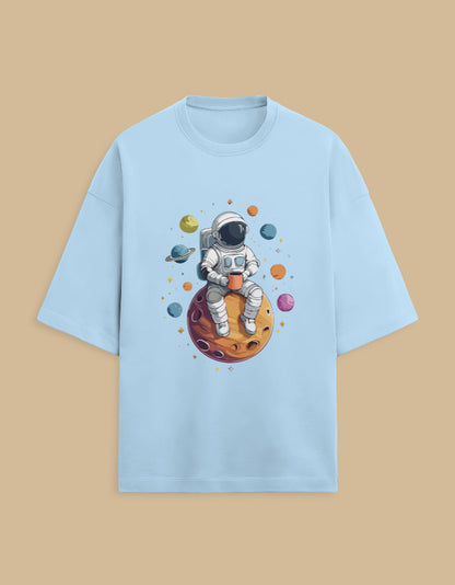 Light blue t-shirt with astronaut drinking coffee on planet and colorful space illustration