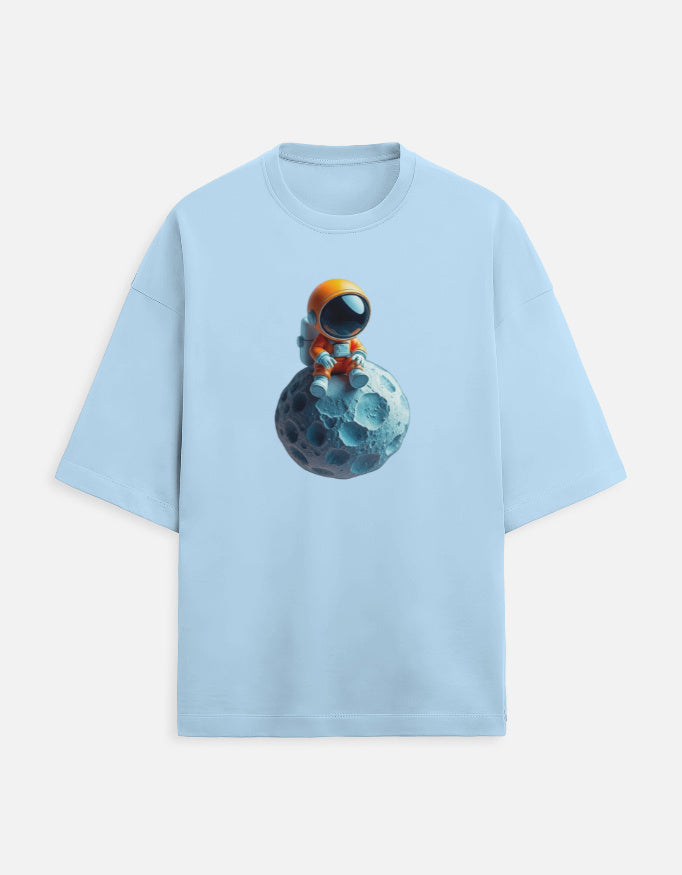 Light blue t-shirt with cartoon astronaut in orange suit sitting on blue moon graphic