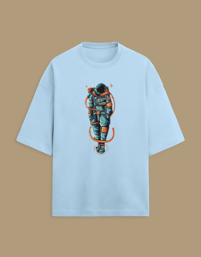 Light blue t-shirt with graphic astronaut design on front, isolated on tan background