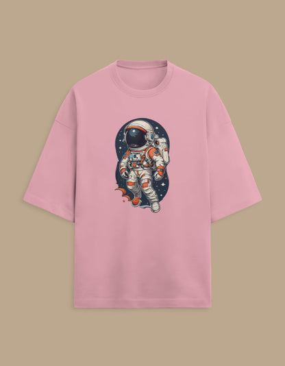 Pink t-shirt with cartoon astronaut space graphic, front view on beige background