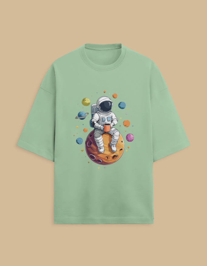 Green t-shirt with astronaut sitting on planet graphic and colorful space theme