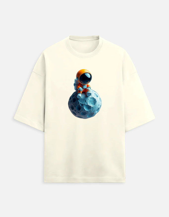 Beige t-shirt with cartoon astronaut sitting on a blue moon graphic