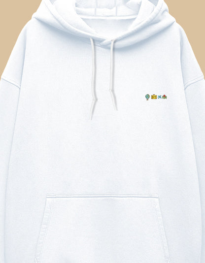 White oversized hoodie with small embroidered travel icons on the left chest