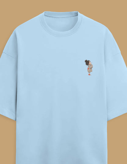 Women's oversized Light blue t-shirt with a small embroidered design on a beige background