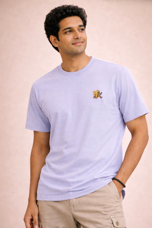 Man wearing a light purple t-shirt with a logo on a beige background