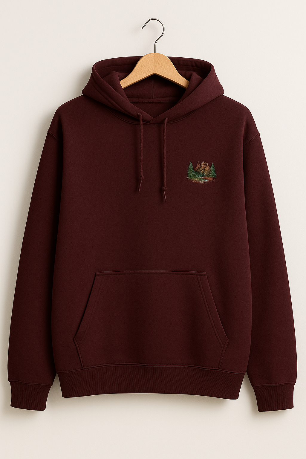 Color_Maroon_Men’s maroon embroidered hoodie with forest design, kangaroo pocket, and adjustable drawstring hood—displayed on hanger against neutral background.”