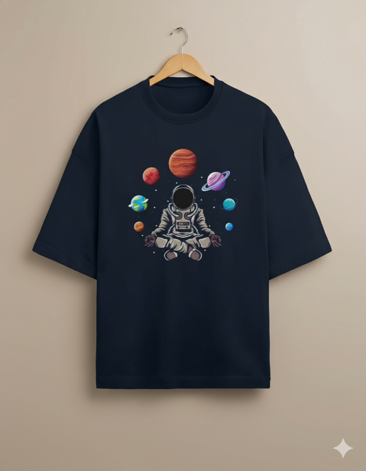 Black t-shirt with astronaut and colorful planets graphic, hanging on wooden hanger